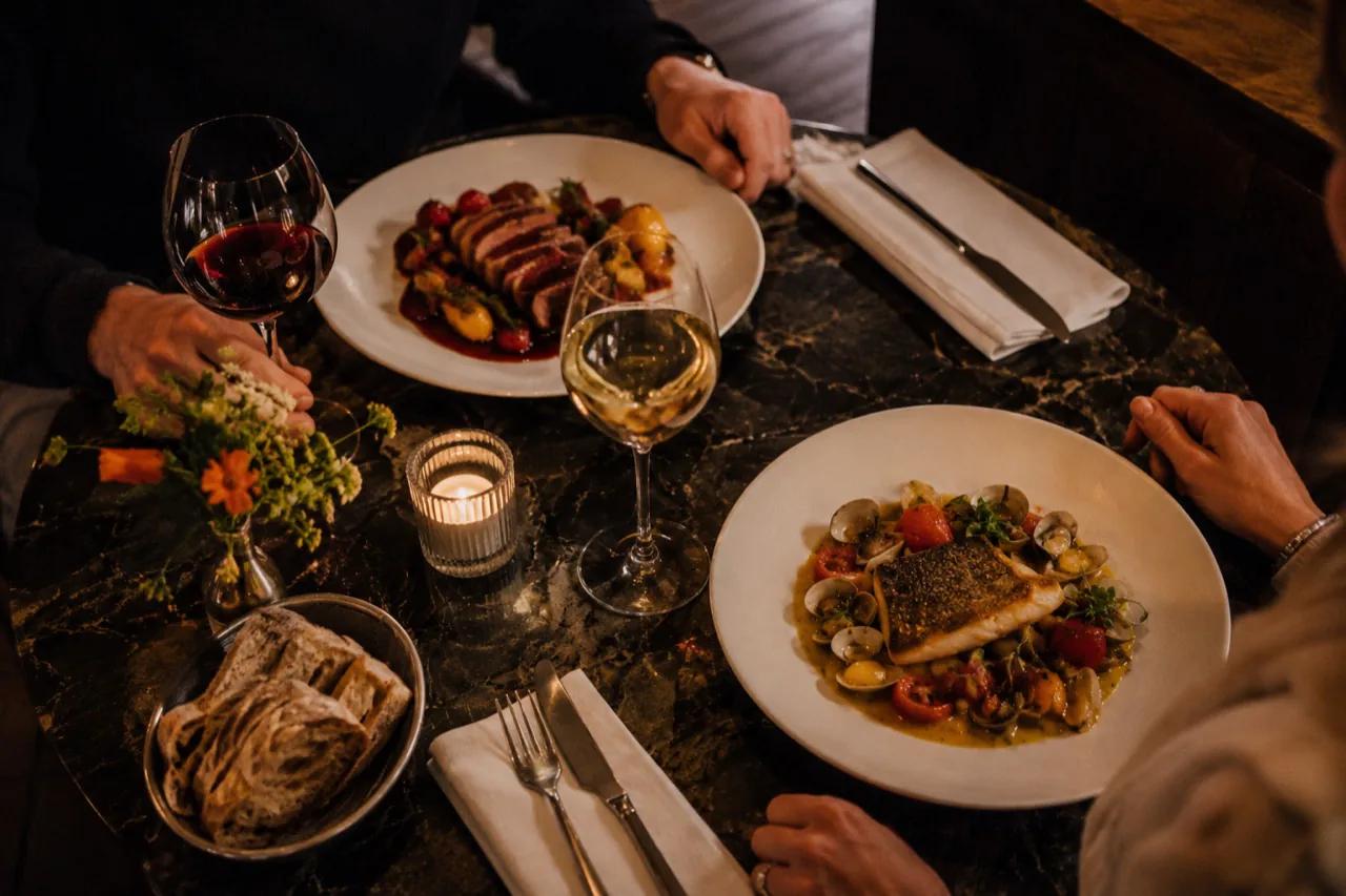 Deux personnes à table avec des plats colorés au restaurant