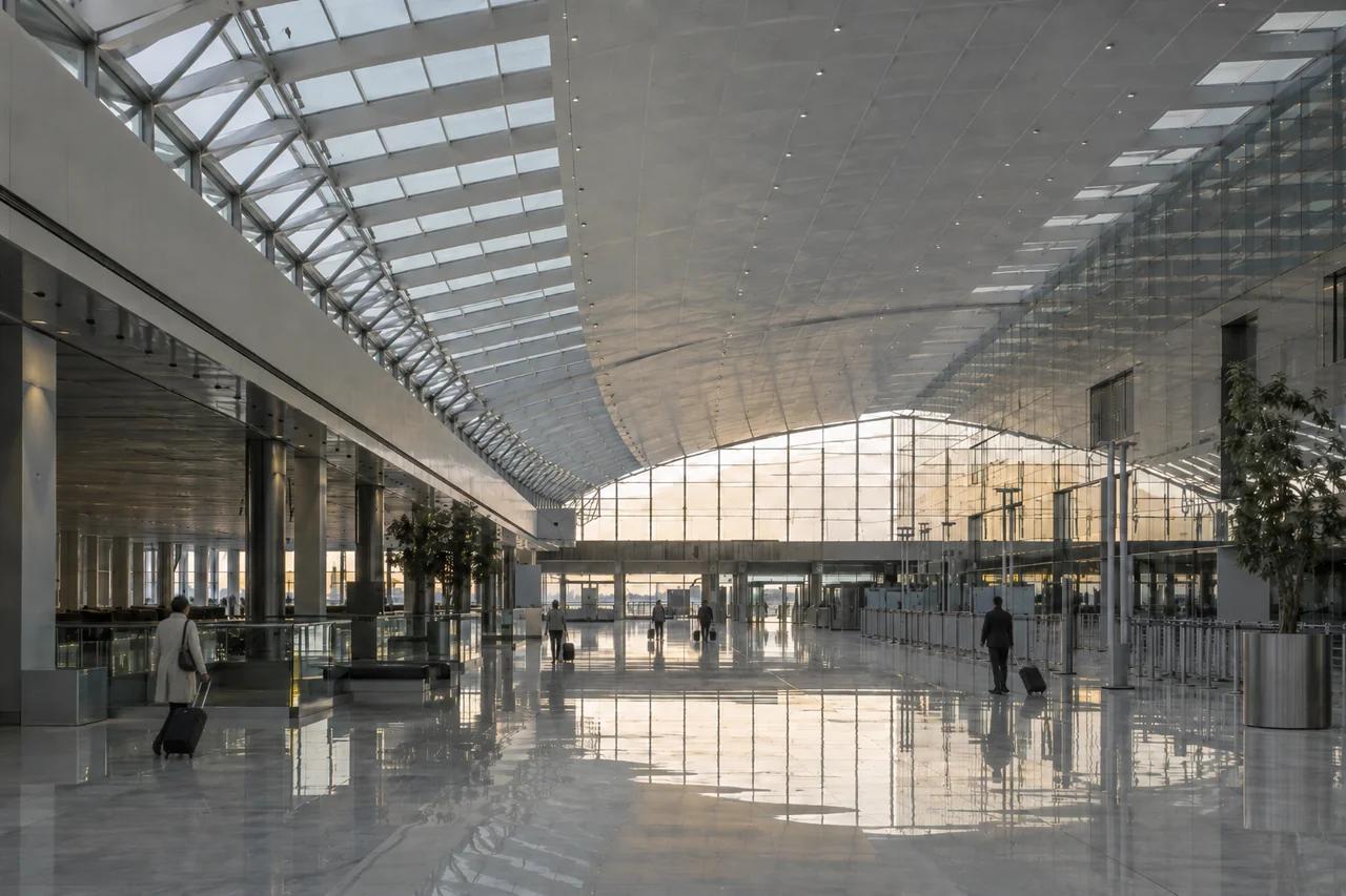 Grand hall intérieur d'un terminal de l'aéroport Roissy-Charles-de-Gaulle avec voyageurs